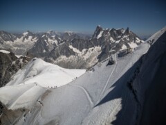 A view fram Aiguille de Midi to the north. It showes a view alpinists on the last step to the station of Aiguille de Midi. Chamonix, France. A view fram Aiguille de Midi to the north. It showes a view alpinists on the last step to the station of Aiguille de Midi. Chamonix, France.
